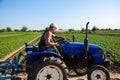 The farmer drives a tractor on the farm. Agroindustry and agribusiness. A man driver works in the field. Farm machinery