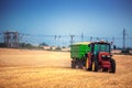 Farmer driving agricultural tractor and trailer full of grain
