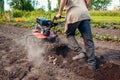 Senior farmer driving small tractor harvesting, digging potato. Autumn harvest vegetables picking. Agriculture