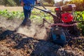 Farmer driving small tractor for soil cultivation and potato digging. Autumn harvest potato picking Royalty Free Stock Photo