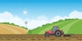 Farmer driving a tractor in farmed land on rural farm landscape hill background