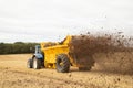 Farmer driving a tractor with a muck spreader. UK