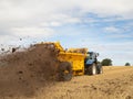 Farmer driving a tractor with a muck spreader. UK