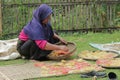 a farmer drying food in the form of crackers to dry in the hot sun