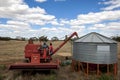 A farmer empties grain from his harvester into a field silo.