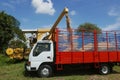 A farmer feeding rice grain from a paddy machine to truck