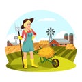 Woman with pitchfork in front of field with hay