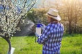 Gardener using crop sprayer in orchard Royalty Free Stock Photo