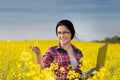 Farmer girl with laptop in rapeseed field Royalty Free Stock Photo