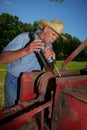 Farmer Greases his Hay Baler Royalty Free Stock Photo