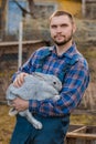 Farmer handsome european caucasian rural portrait in countryside with beard, shirt and overalls looking at camera with white