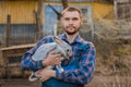 Farmer handsome satisfied european caucasian rural portrait in countryside with beard, shirt and overalls looking at camera with