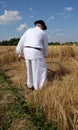 Farmer harvesting wheat with scyth Royalty Free Stock Photo