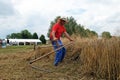 Farmer harvesting wheat with scythe