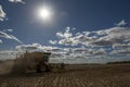 A farmer harvests a broadacre paddock of wheat.