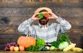 Farmer having fun wooden background. Man hold pepper harvest as funny emotional grimace. Pepper harvest concept. Chilli