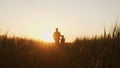 Farmer and his son in front of a sunset agricultural landscape. Man and a boy in a countryside field. Fatherhood Royalty Free Stock Photo