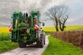 farmer and his tractor equip with a sprayer leaving for work in the spring