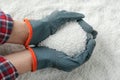 Farmer holding ammonium nitrate pellets in hands over pile, top view. Mineral fertilizer