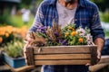 A farmer holding a crate of colorful flowers at a local farmers\' market. Royalty Free Stock Photo