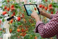 Farmer holding a tablet smart arm robot harvest work agricultural machinery