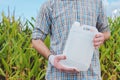 Farmer holding unlabeled pesticide jug in field Royalty Free Stock Photo