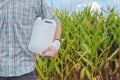 Farmer holding unlabeled pesticide jug in field Royalty Free Stock Photo