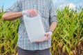 Farmer holding unlabeled pesticide jug in field Royalty Free Stock Photo