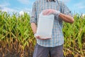 Farmer holding unlabeled pesticide jug in field Royalty Free Stock Photo