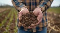 A farmer holding up a sample of healthy soil citing the positive impact of using automated sensors for improved yields