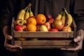 The farmer is holding a wooden box full of fresh fruits. Fruit basket apples, bananas, oranges. ai generative Royalty Free Stock Photo