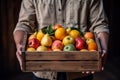 The farmer is holding a wooden box full of fresh fruits. Fruit basket apples, oranges. ai generative Royalty Free Stock Photo