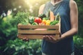 Farmer holding wooden box full of fresh raw vegetables. Concept of bio products, bio ecology, grown by yourself, vegetarians. Royalty Free Stock Photo