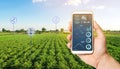 The farmer holds a phone and receives information parameters and data from agricultural field. Advanced technologies in