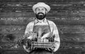 Farmer with homegrown vegetables in basket. Man bearded farmer presenting eco vegetables wooden background. Fresh Royalty Free Stock Photo