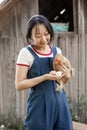 The farmer hugs a hen. pleasant asian woman is hugging a cock in countryside.