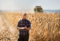 Farmer looking at corn grains in tractor trailer