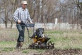 Farmer loosens the soil cultivator