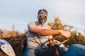 Farmer man with the plague mask on, driving an old tractor in the middle of his farmland. Royalty Free Stock Photo