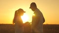 Farmer man and woman work with a tablet in wheat field in sun. silhouette of agronomist and businessman with tablet Royalty Free Stock Photo