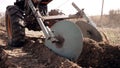 Farmer man works, ploughing in garden chernozem field with motorized unit motoblock - type of small-sized tractor, used Royalty Free Stock Photo