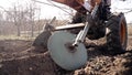 Farmer man works, ploughing in garden chernozem field with motorized unit motoblock - type of small-sized tractor, used Royalty Free Stock Photo