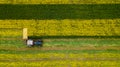 A farmer mowing grass using a tractor with a rotary mower