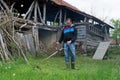 Farmer mowing tall grass in a village in the backyard with hand lawn gasoline mower