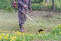 Closeup of a worker in special clothes with a gas mower in his hand Royalty Free Stock Photo