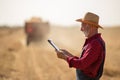 Farmer with notebook in field during harvest Royalty Free Stock Photo