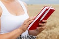 A farmer with a notebook in his hands checks the ripening of the harvest A yellow agricultural field with ripe wheat The Royalty Free Stock Photo