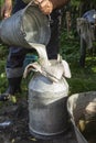 Farmer passes the milk through the strainer, the old way of cleaning milk from dirt