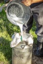 Farmer passes the milk through the strainer, the old way of cleaning milk from dirt