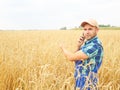 Farmer in a plaid shirt controlled his field. Talking on the phone. Royalty Free Stock Photo